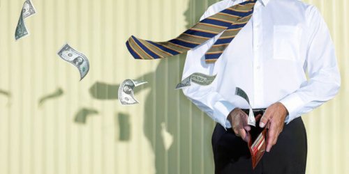 Uomo con portafoglio aperto che perde soldi