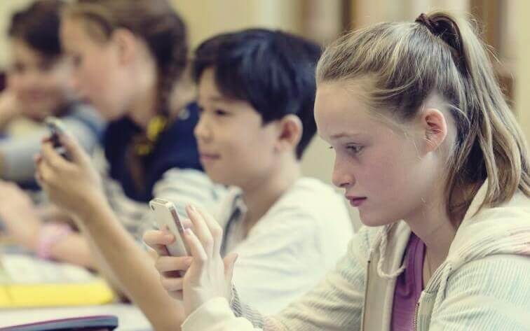 Adolescenti in classe con il cellulare