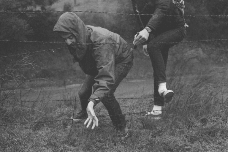 Persona che scappano dal filo spinato