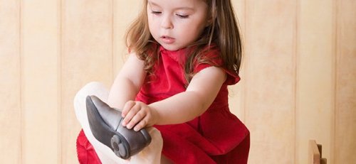 Una bambina che si mette le scarpe