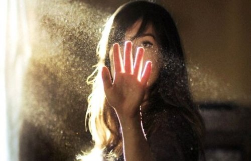 Donna che mette la mano in un fascio di luce