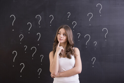 Ragazza circondata da punti interrogativi