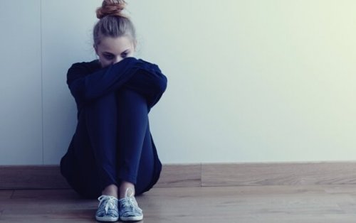 Ragazza seduta a terra con braccia incrociate