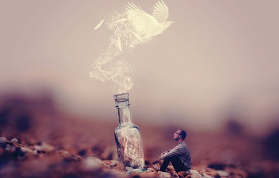 Uomo in miniatura davanti a bottiglia da cui esce una colomba