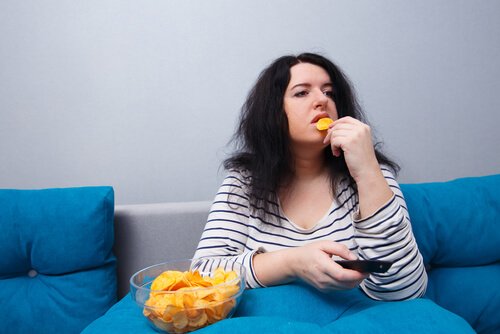 Una donna che mangia patate la sedentarietà