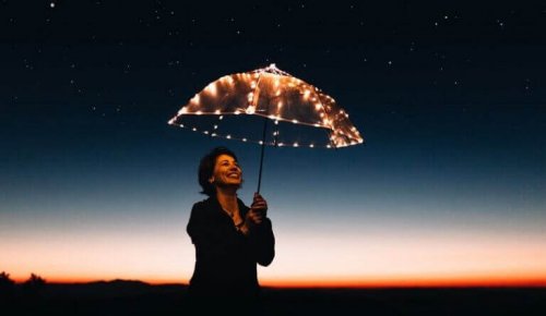 Donna con un ombrello illuminato da luci