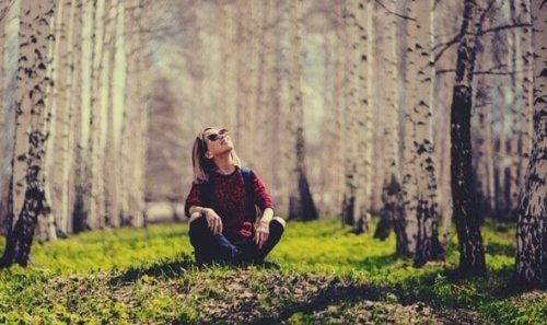 Donna single seduta in un bosco