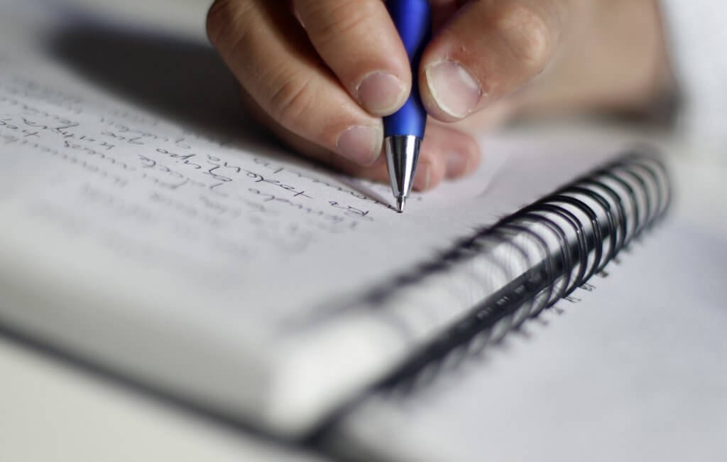 Mano che scrive su un blocco