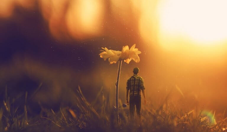 Uomo in miniatura sotto un fiore