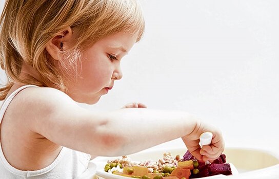 Bambina che mangia verdure