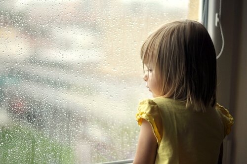 Bambina che guarda dalla finestra