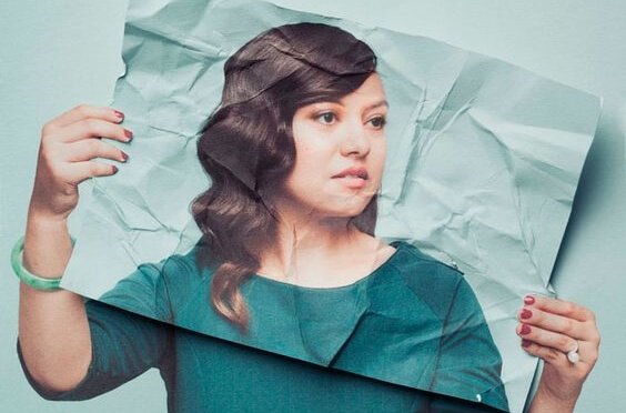 Donna nascosta dietro la propria fotografia