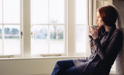 DOnna che beve un tè davanti alla finestra