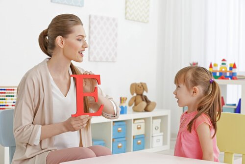 Mamma mostra una lettera alla sua bambina che impara a parlare
