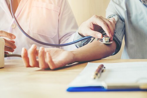 Medico che misura pressione arteriosa al suo paziente