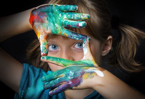Bambina con mani colorate