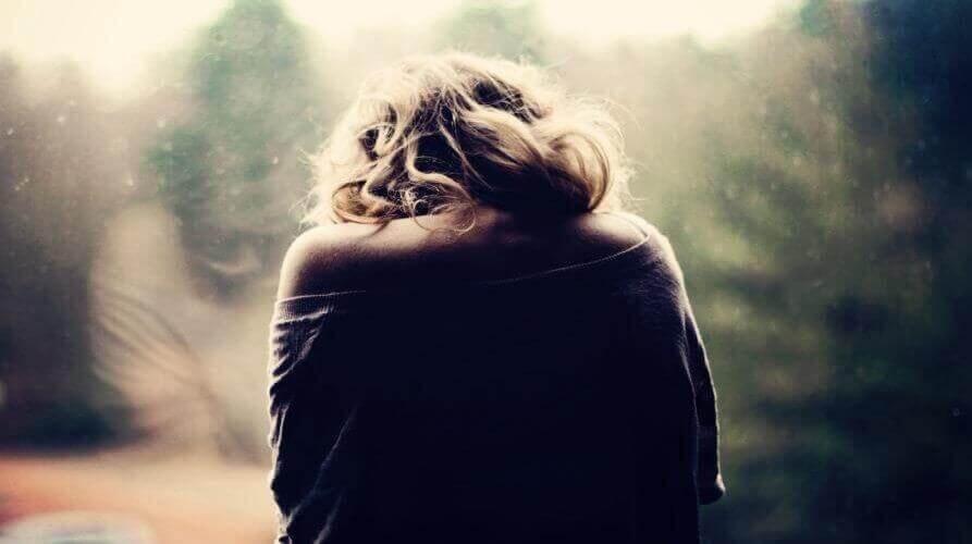 Donna di spalle davanti alla finestra