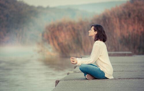 Donna medita al lago gestire lo stress