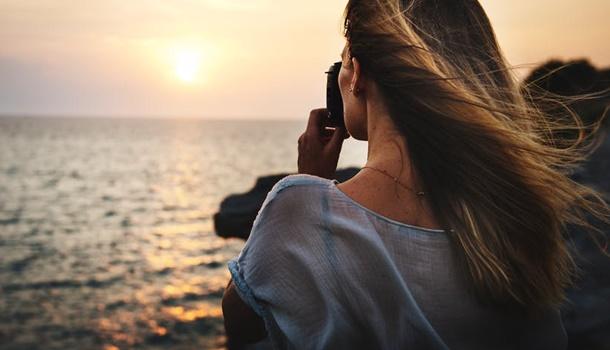 Ragazza che scatta foto al mare