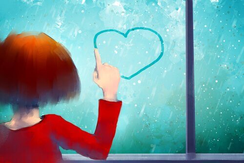 Bambina che col dito disegna cuore su finestra