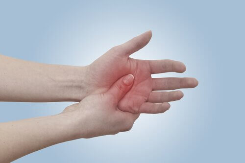 Donna con dolore alla mano per artrite reumatoide