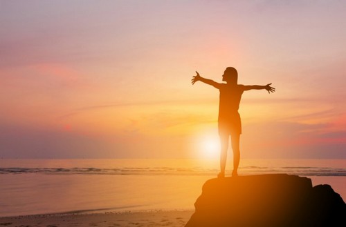 Ragazza braccia aperte tramonto