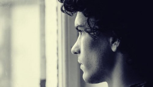 Ragazzo che guarda fuori da una finestra e rappresenta le conseguenze di un legame tossico
