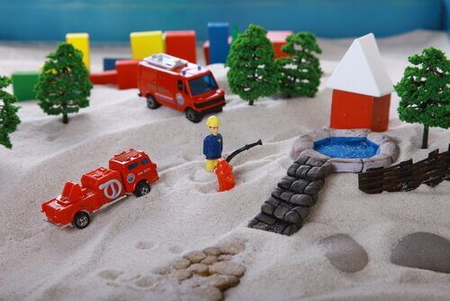 Sabbia con sopra pompieri giocattolo