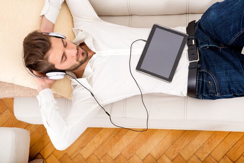 Uomo sul divano che ascolta la musica