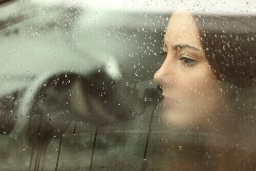 Donna triste guarda dalla finestra
