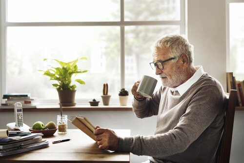 Uomo anziano con tazza e libro