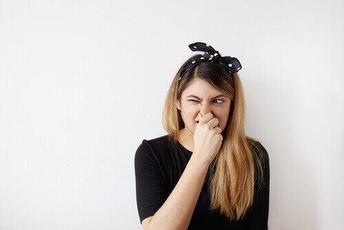 Ragazza che si tappa il naso e fa smorfia