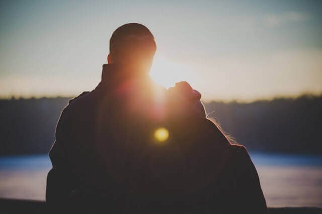 Coppia di spalle con donna che appoggia testa su uomo