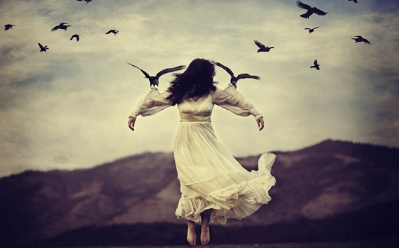 Donna vestita di bianco sorretta da uccelli