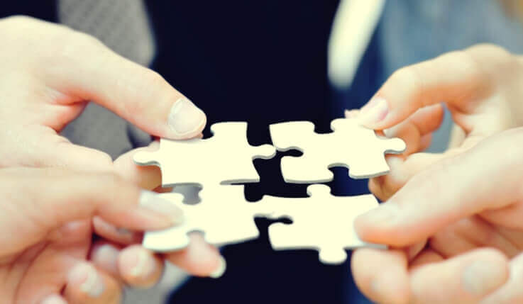 Mani che uniscono pezzi di puzzle