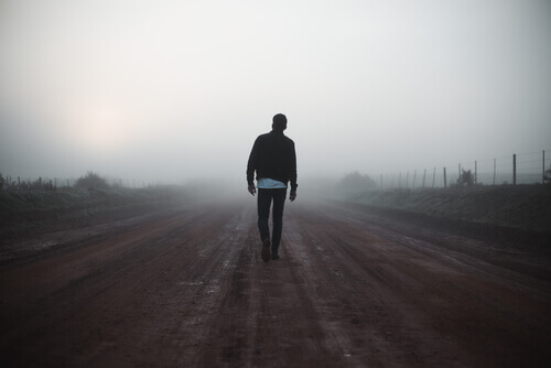 Uomo cammina nella nebbia.