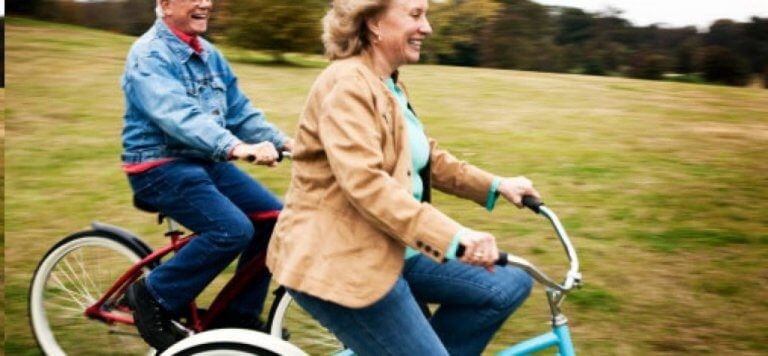Coppia anziana felice in bicicletta