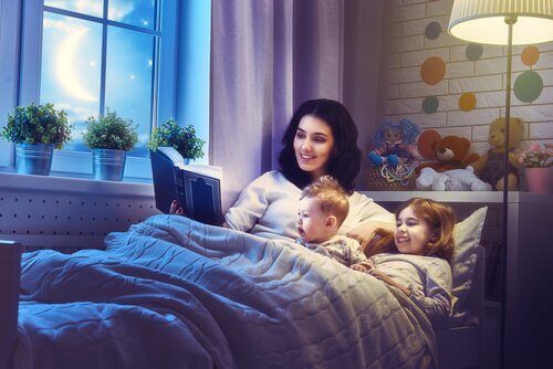 Madre nel letto con bambini che legge favola