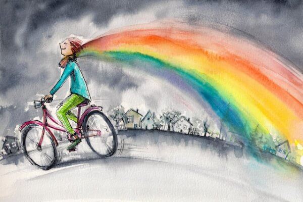Ragazza in bicicletta con sciarpa arcobaleno