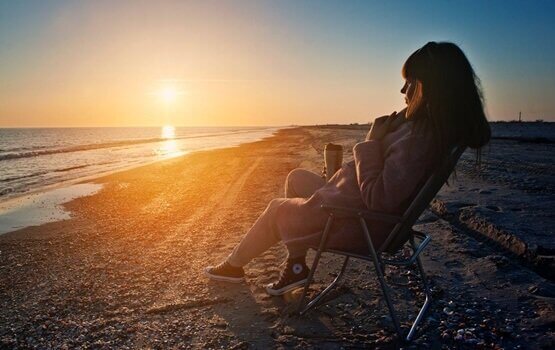 Donna che si rilassa in spiaggia durante il tramonto