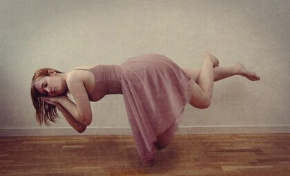 Ragazza vestita di rosa che dorme sollevata da terra