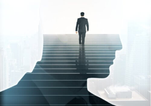 Uomo sale una scalinata all'interno di una sagoma a forma di testa