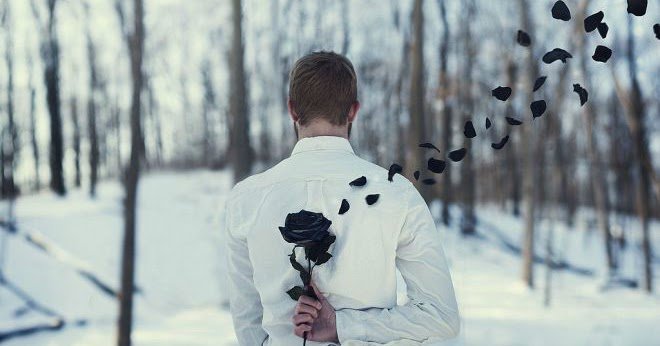 Uomo nasconde una rosa nera dietro la schiena