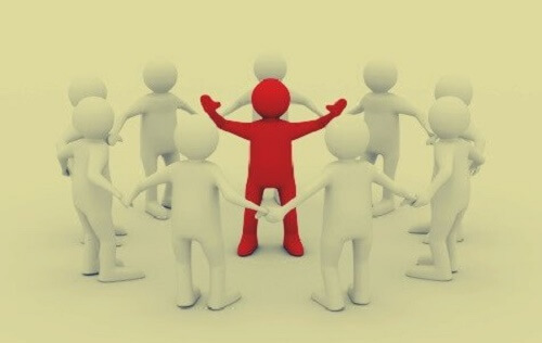 Omino rosso circondato da omini bianchi