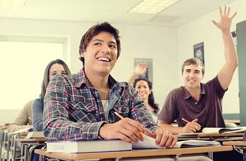 Alunno alza la mano in classe dimostrando motivazione all'apprendimento