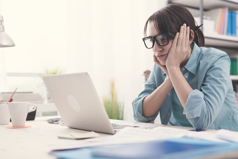 Donna guarda il computer annoiata