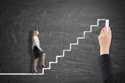 Donna percorre scala disegnata su lavagna