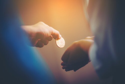 Mano che dona una moneta