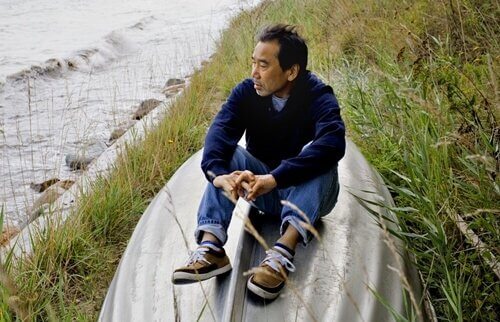 Murakami seduto sulla sponda di un fiume