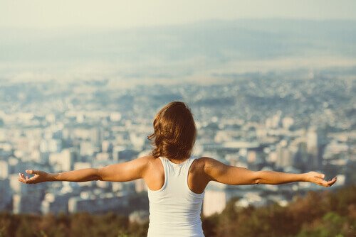 Ragazza con braccia aperte sulla città.